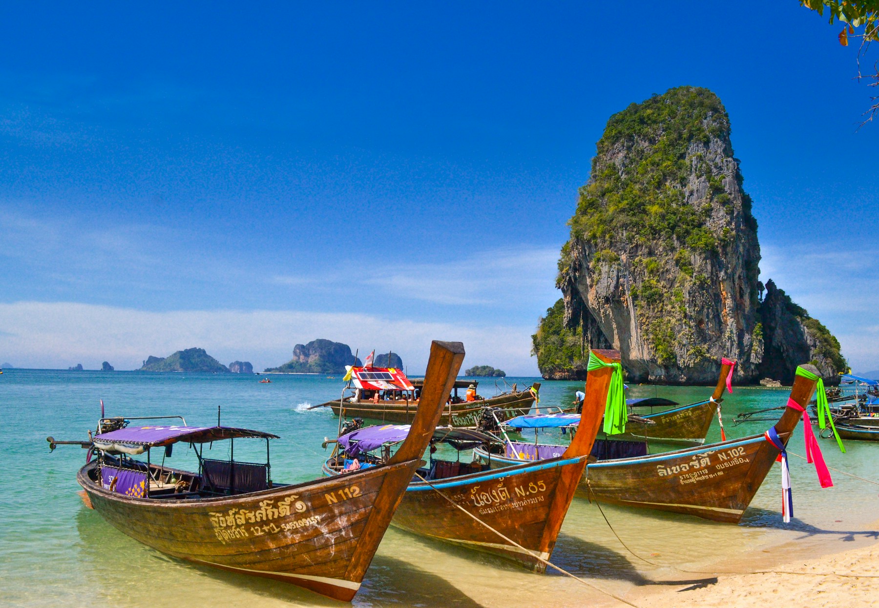 Traditional long-tail boats beside Thailand's limestone islands